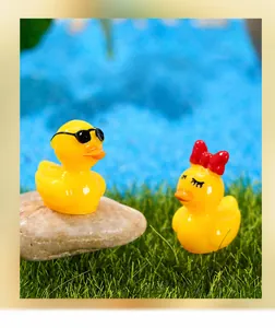 Detail of miniature resin ducks featuring a male with sunglasses and female with a bow