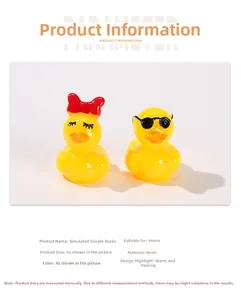 Detailed view of yellow resin couple duck figurines with sunglasses and red bow tie decor