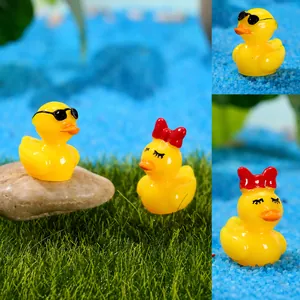 Detailed close-up of mini resin duck figurines in moss and sand micro landscape decor
