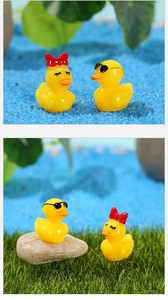 Gros plan de figurines de canard en résine avec nœud rouge et lunettes pour paysages