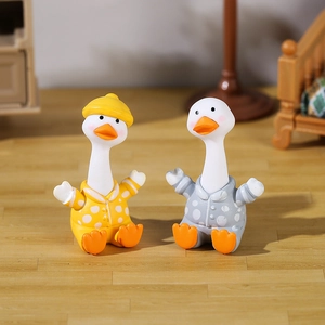 Cute set of two miniature resin ducks in yellow and grey polka dot pajamas for desk decor