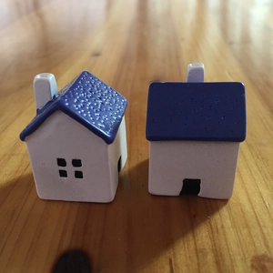 Close-up of miniature white resin houses with blue roofs on a wooden surface