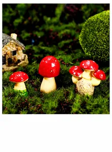 Three red miniature mushrooms with white spots set in a lush green moss micro-landscape