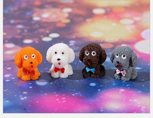 Four miniature resin teddy dog figurines in orange, white, chocolate, and grey with bows