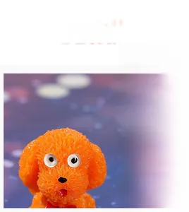 Detail of miniature orange poodle resin figurine with textured fur and red bow tie