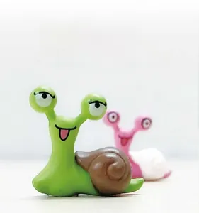 Close-up of cute pink and green snail miniatures for moss DIY landscape decor