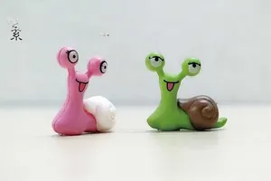 Macro shot of cute PVC snail figurines with googly eyes for moss micro landscapes