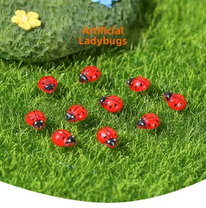 Miniature di coccinelle su erba artificiale per decorazione di micro paesaggi