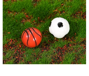 Detalle macro de un balón de baloncesto y fútbol miniatura sobre musgo verde