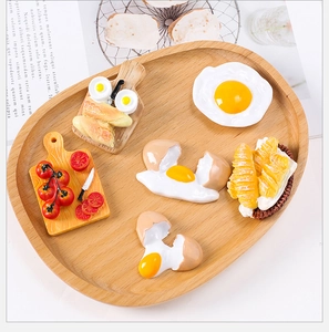 Detail view of realistic resin food magnets including eggs and bread on a wooden tray