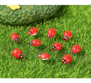 Macro shot of 10 miniature wooden ladybugs with red shells on green moss for DIY garden decor