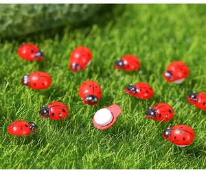 Macro view of miniature self-adhesive wooden ladybugs on green grass for DIY decor