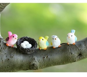 Macro detail of miniature resin bird figurines and nest for succulent landscape decor