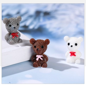 Macro shot of three miniature resin bears with fur texture and 3D bowknot details