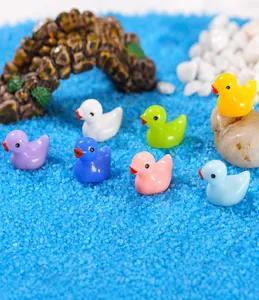 Group of seven colorful miniature resin ducks in a scenic moss micro landscape setting