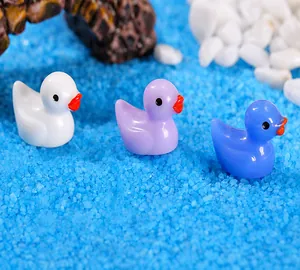 Macro shot of colorful mini resin ducks in a miniature moss landscape setting