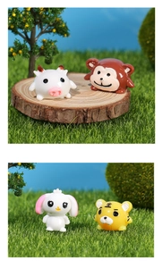 Macro detail of resin miniature animal figurines including tiger and rabbit on moss