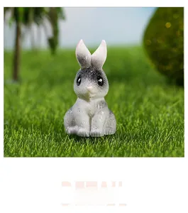 Detailed view of a miniature resin rabbit figurine sitting on a green mossy lawn