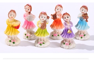 Detail view of six miniature flower fairy resin statues playing musical instruments