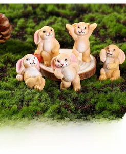 Set of five cute miniature resin bunnies in various poses on green moss and wood base