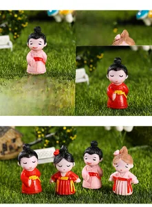 Close-up of resin couple miniatures in traditional outfits for micro landscape decor