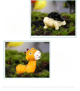 Detailed macro view of resin giraffe and turtle figurines on green moss background