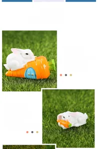 Detail of cute resin rabbit and carrot figurines on green grass for micro landscape