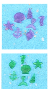 Macro detail of assorted resin sea creatures and shells on blue decorative sand