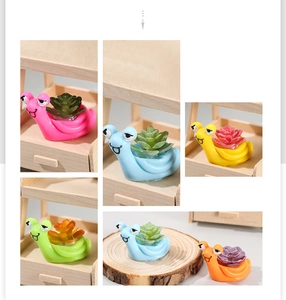 Close-up of miniature colorful resin snails with artificial succulents for moss landscape