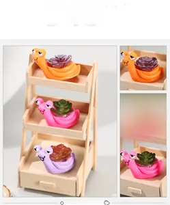 Detailed view of three colorful snail figurines with miniature artificial succulents on a rack