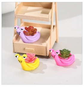 Detailed view of three resin snail figurines with faux succulents in pastel colors
