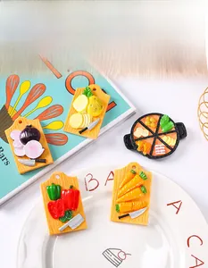 Close-up of resin refrigerator magnets featuring 3D vegetables and hotpot on a mini board