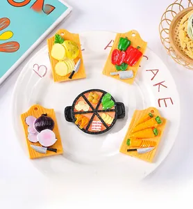 Detailed view of realistic miniature cutting boards and pan food fridge magnets in a tray