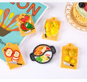 Detailed flat lay of miniature resin food magnets including fruit boards and hot pot