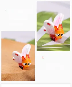 Close-up of artificial resin butterfly garden ornament with adjustable wings and cute face