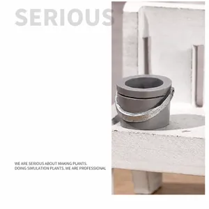 Cubo en miniatura gris con mango plateado sobre un banco para decoración de casas de muñecas