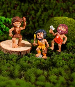 Macro shot of resin caveman miniatures on moss and logs for micro landscape DIY decor