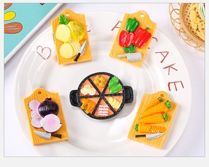 Detail of five miniature kitchen resin magnets showing veggies and hotpot on a white plate