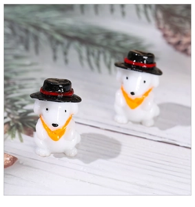 Macro view of miniature resin puppy figurines with black top hats and orange scarves