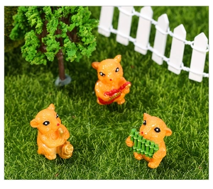 Detailed view of three resin hamster musicians on a miniature lawn with a white fence
