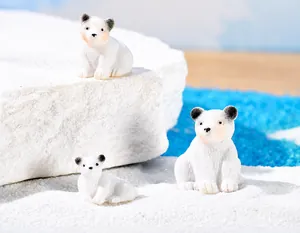 Detailansicht von drei Miniatur-Eisbärenfiguren aus Harz in einer Mikro-Schneelandschaft