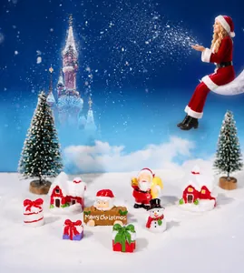 Miniature Christmas resin figurines including Santa Claus and snowmen on fake snow