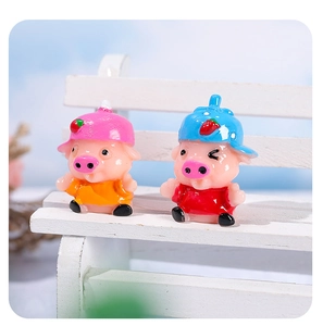 Détail de mignonnes figurines de cochons en résine avec chapeaux fraise sur un banc