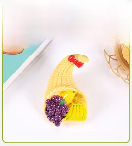 Detailed resin miniature fruit basket magnet with realistic corn texture and red bow