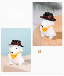Detailed close-up of miniature resin puppy wearing a black top hat and yellow scarf ornament