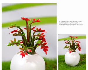 Macro detail of artificial succulent with red-green gradient leaves in white ceramic pot