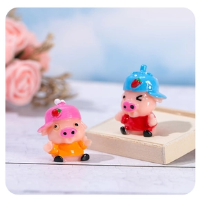 Détail de figurines de cochons mignons en résine avec chapeaux de fraises décoratifs