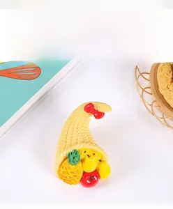 Detailed view of 3D resin fruit cornucopia figurine featuring pineapple and red bow