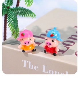 Détail de cochons mignons en résine avec chapeaux fraise sur un livre décoratif