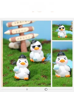 Detailed view of miniature resin duck figurines with hats and sunglasses for decor